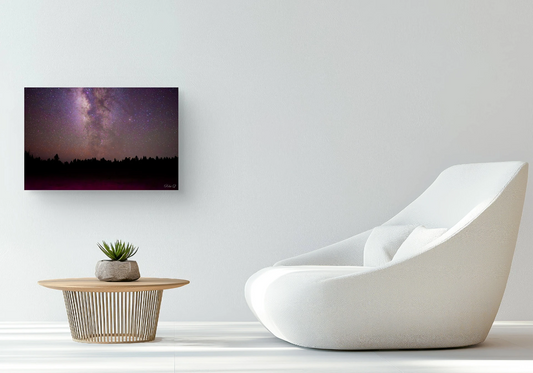 Modern living room with a white chair, small table, and the "Celestial Silence" wall art (of a starry night sky.)