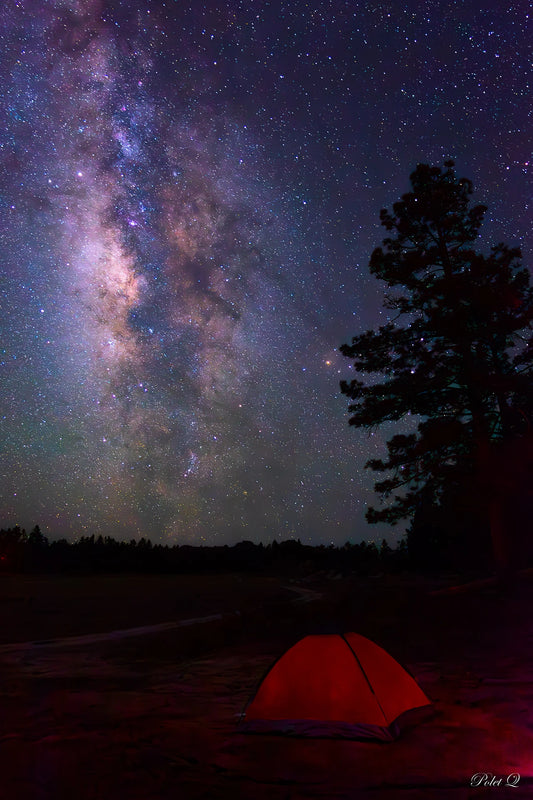 Red tent under a starry night sky with the view of the Milky Way galaxy.